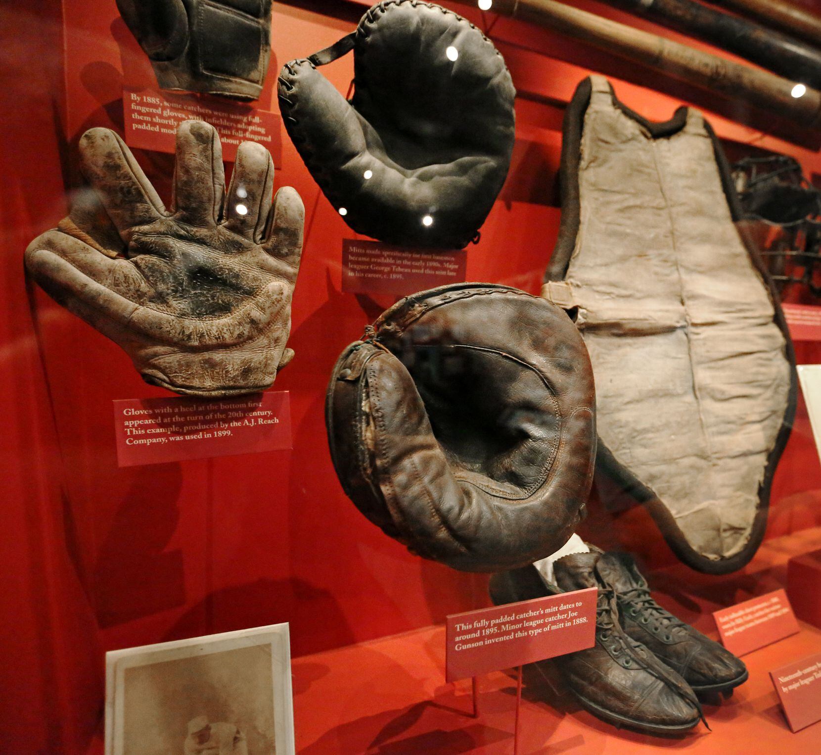 A grouping of early gloves and catchers gear is on display at the Baseball Hall of Fame in...