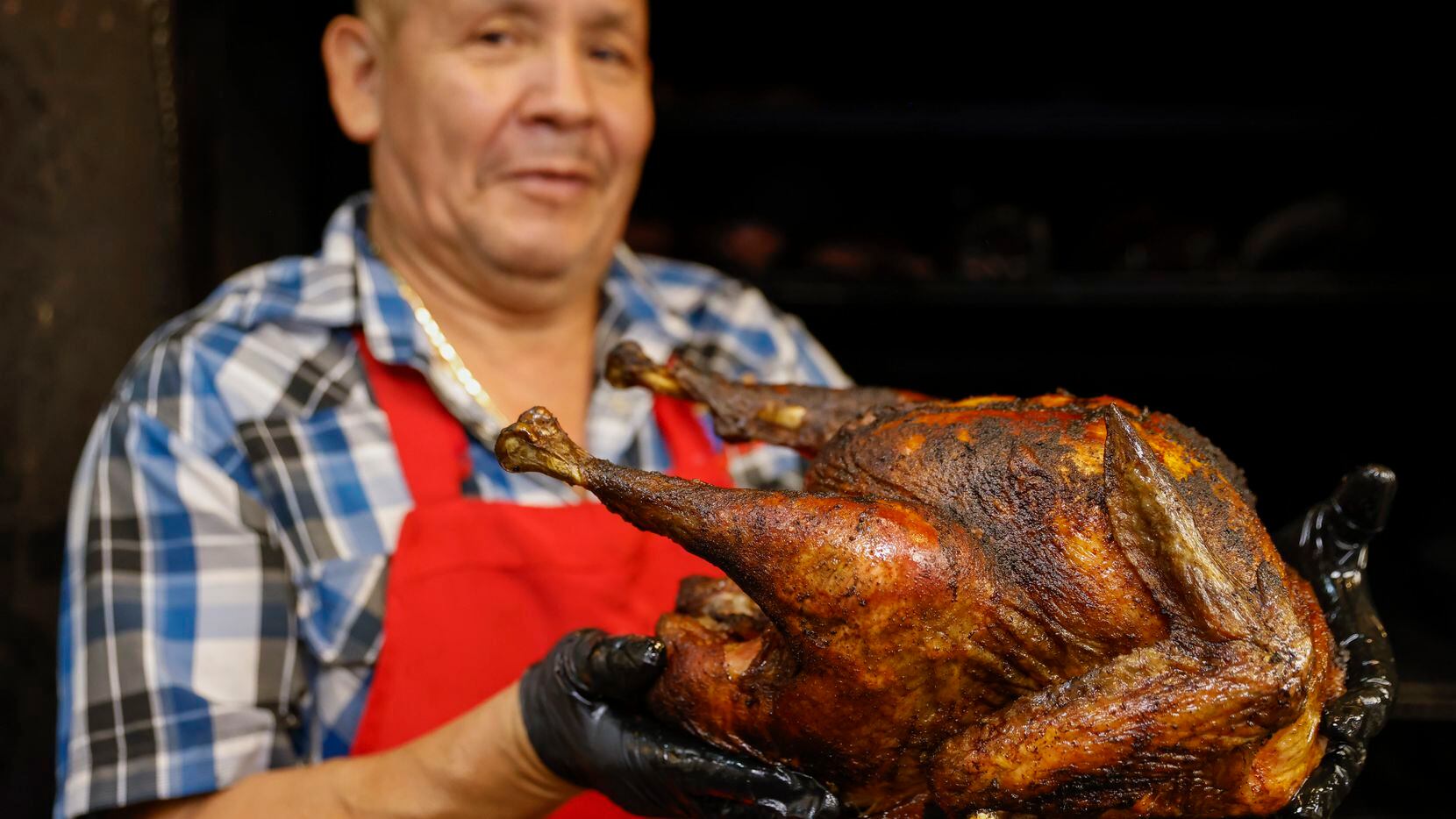 Longtime Big Al's Smokehouse BBQ employee Pedro Garcia shows a roasted turkey for a display...