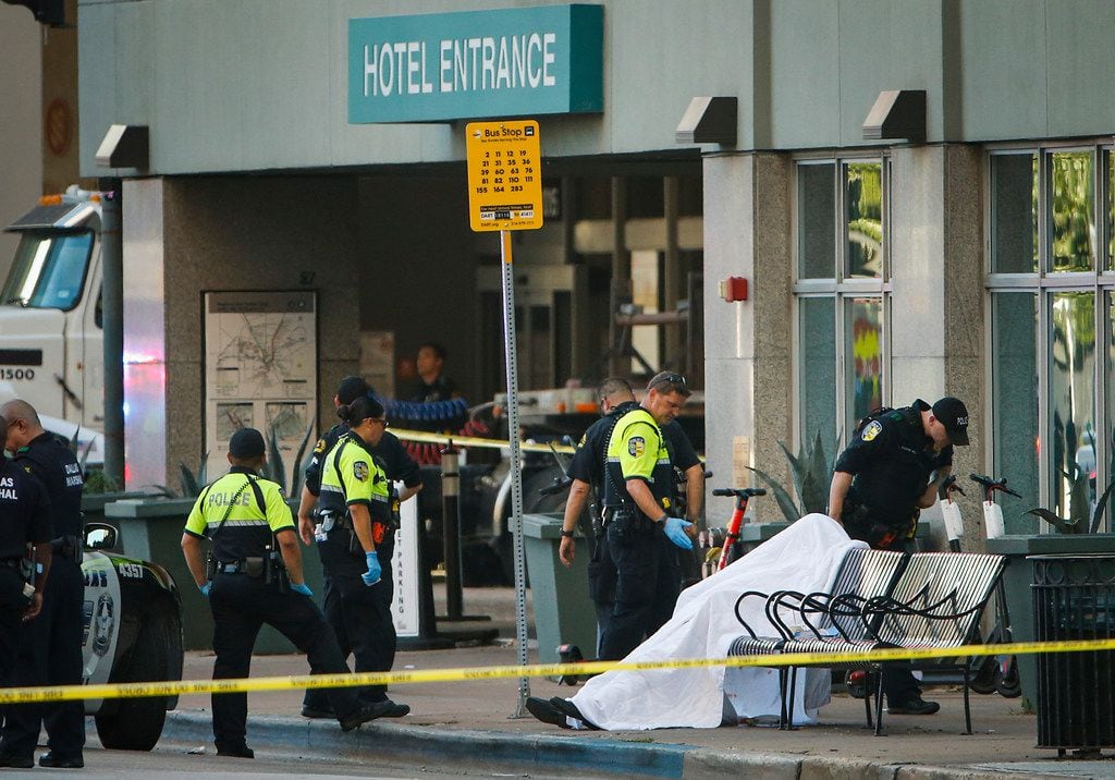 A deceased man's body was covered on a bus stop bench Friday outside the Homewood Suites on...