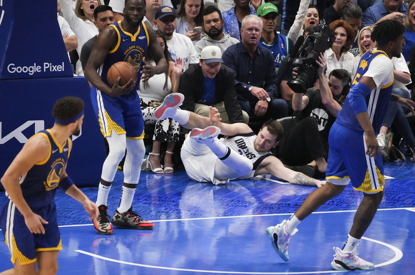 Dallas Mavericks guard Luka Doncic (77) tumbles to the floor after scoring past Golden State...