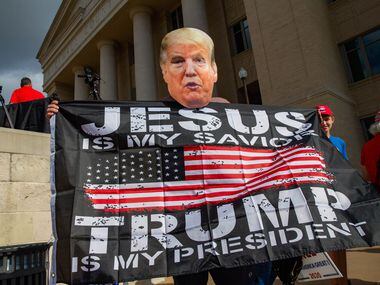 Paul Clay wears President Donald Trump's face as a mask during an America is Great rally...