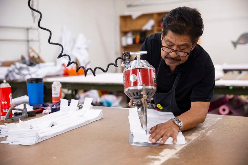 Business owner Rudy Romero cuts fabric at T&Q Cutting Services on May 2, 2020, in Dallas....