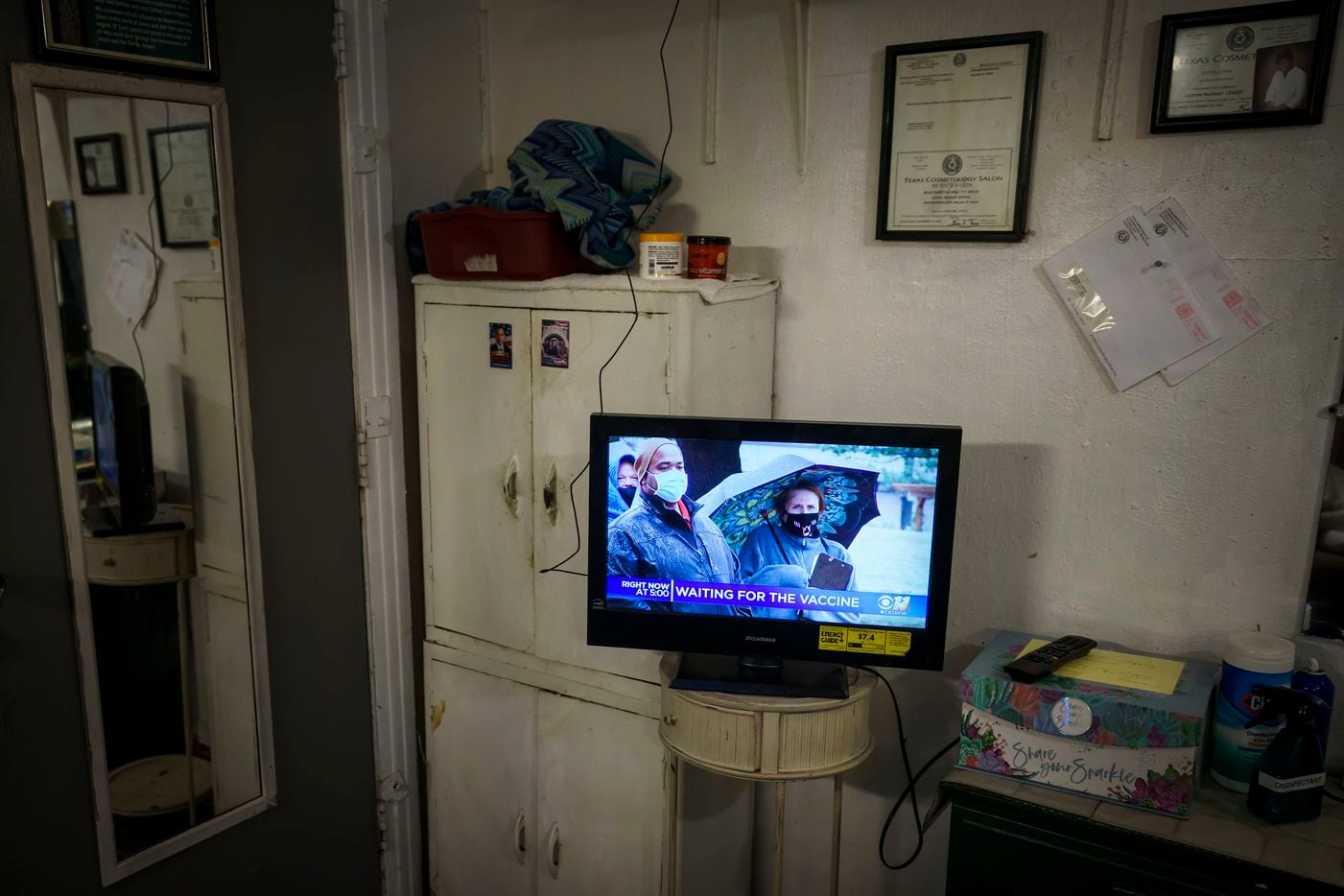 The television in her Earnestine Tarrant’s hair salon in South Dallas show news of people hoping to get the COVID-19 vaccine.