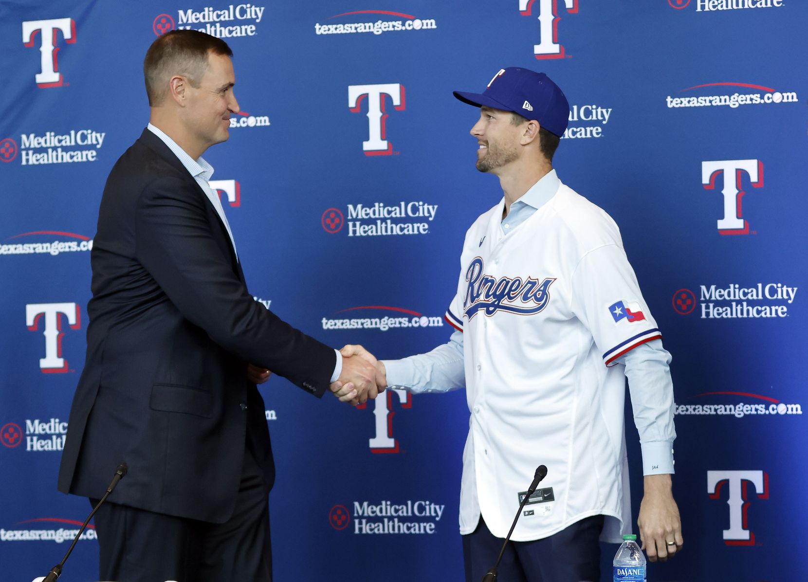 New Texas Rangers starting pitcher Jacob deGrom (right) shakes hands with general manager...