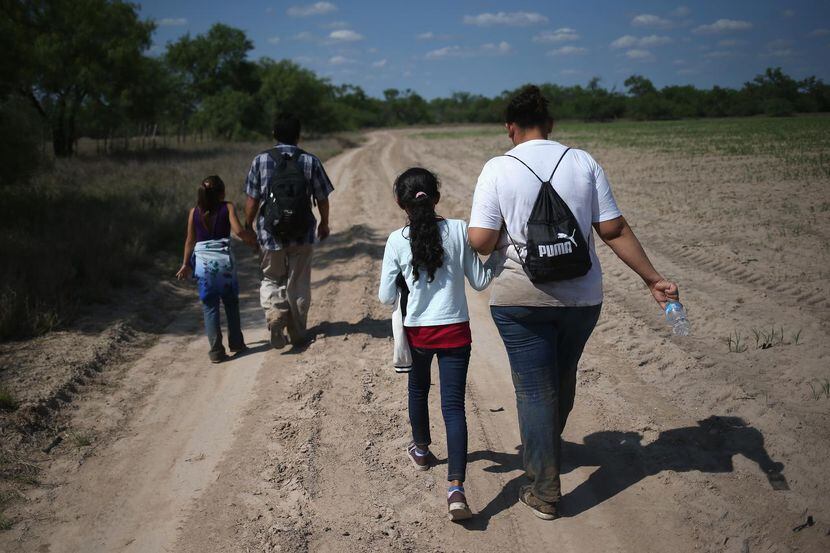 Familias centroamericanas recorren un camino rural luego de cruzar a Estados Unidos en busca...