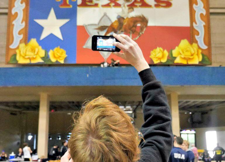 A woman photographs the Coliseum at Fair Park during the State Fair of Texas.