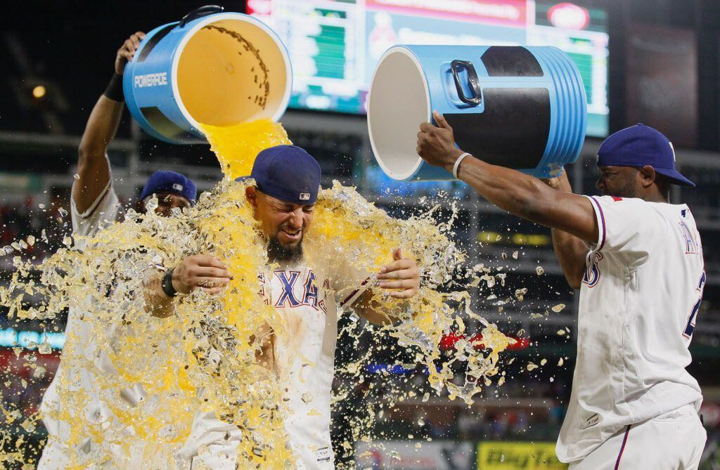 Texas Rangers' Elvis Andrus, left, and Hanser Alberto, right, douse Rougned Odor after...