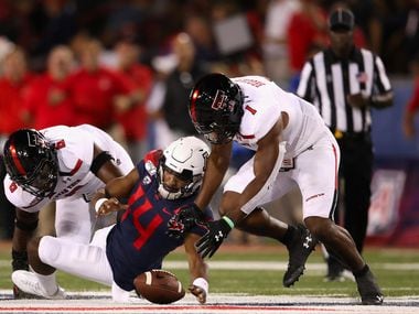TUCSON, ARIZONA - SEPTEMBER 14:  Quarterback Khalil Tate #14 of the Arizona Wildcats fumbles the football as linebackers Riko Jeffers #6 and Jordyn Brooks #1 of the Texas Tech Red Raiders recover during the first half of the NCAAF game at Arizona Stadium on September 14, 2019 in Tucson, Arizona.