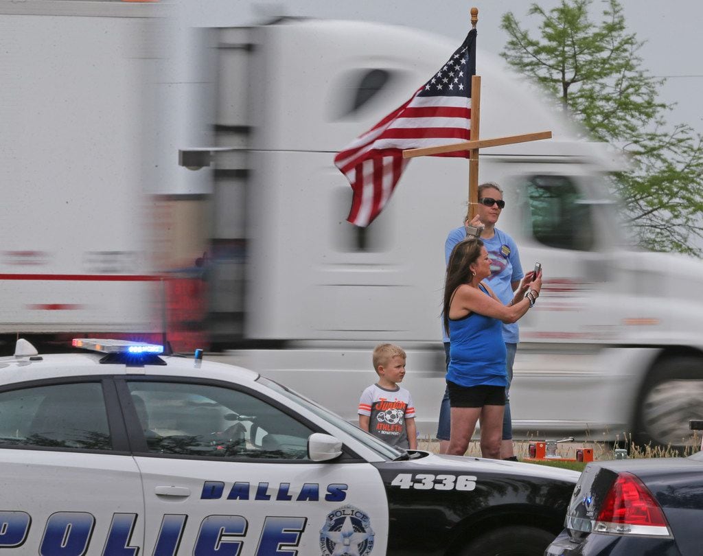Passers-by stop to pay their respects at the funeral for Officer Rogelio Santander Jr. at...