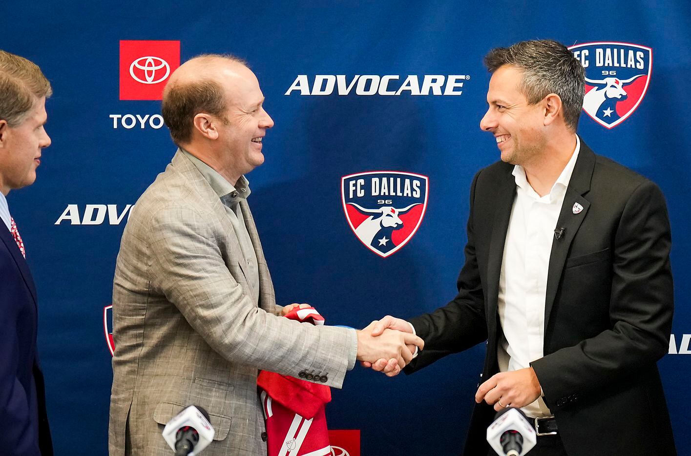 New FC Dallas head coach Nico Estévez (right) shakes hands with team president Dan Hunt as chairman and CEO Clark Hunt looks on during his introductory press conference at the National Soccer Hall of Fame on Friday, Dec. 3, 2021, in Frisco, Texas.