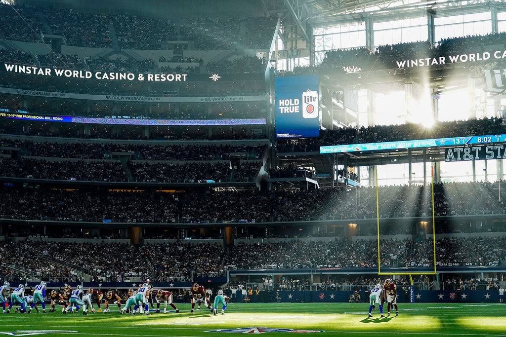 FILE - Sunlight steams through the windows of AT&T Stadium during the first half of a game between the Dallas Cowboys and Washington on Sunday, Dec. 29, 2019, in Arlington.