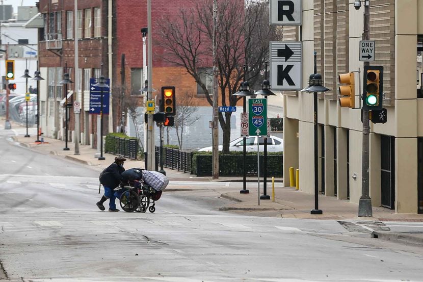 Un hombre cruza una calle en el centro de Dallas el sábado, con temperaturas por abajo de...