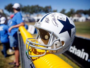 A signed Dallas Cowboys helmet sits along the fence following their last practice of...
