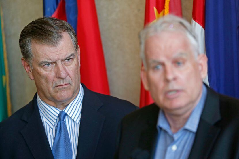 Mayor Mike Rawlings (left) watches Neville R. Ray, Executive Vice President and Chief...