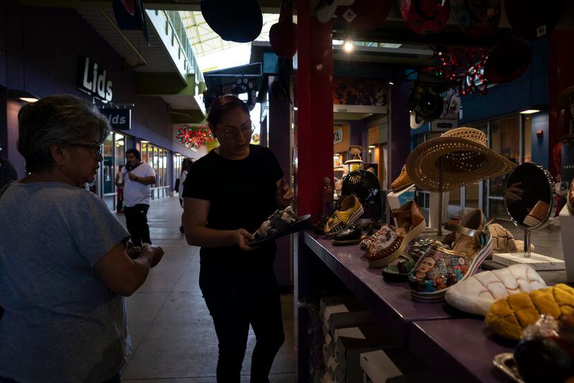 Maria Olivares, 32, muestra algunos de sus productos a una cliente mexicana en el stand de...