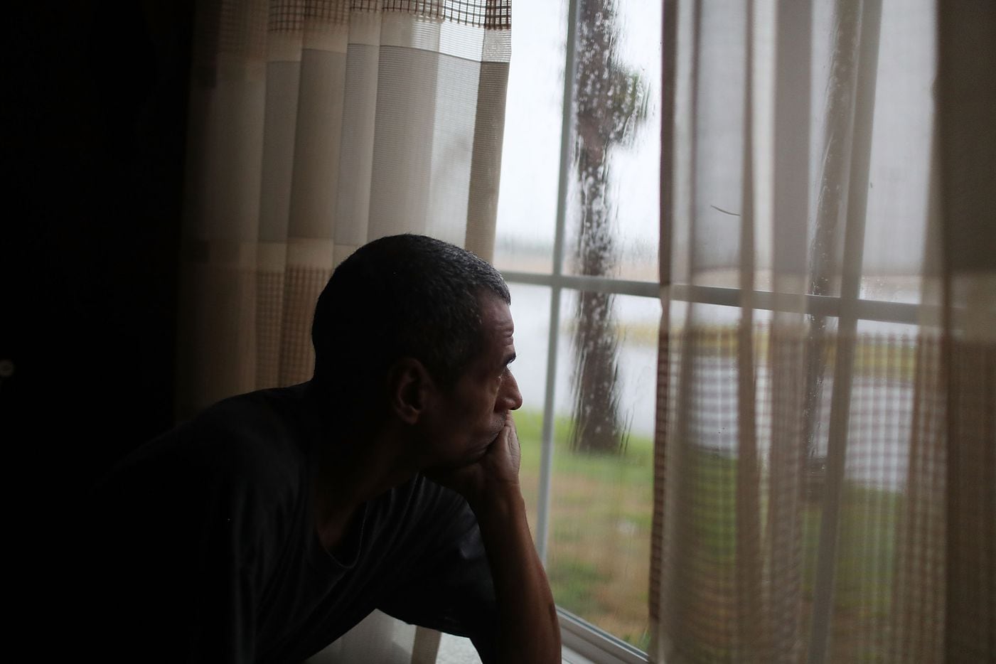 Derrell Rollins looks out of the window of the TownePlace Suites hotel as he takes shelter...
