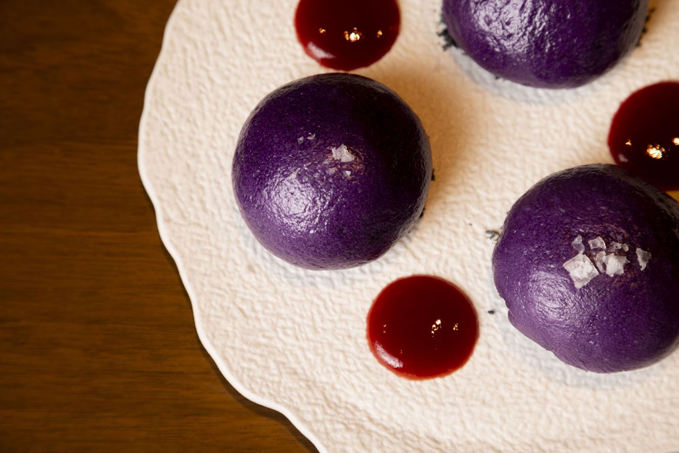 The dessert Ube Nutella Bao is prepared with coconut charcoal, strawberry sauce, sea salt at...