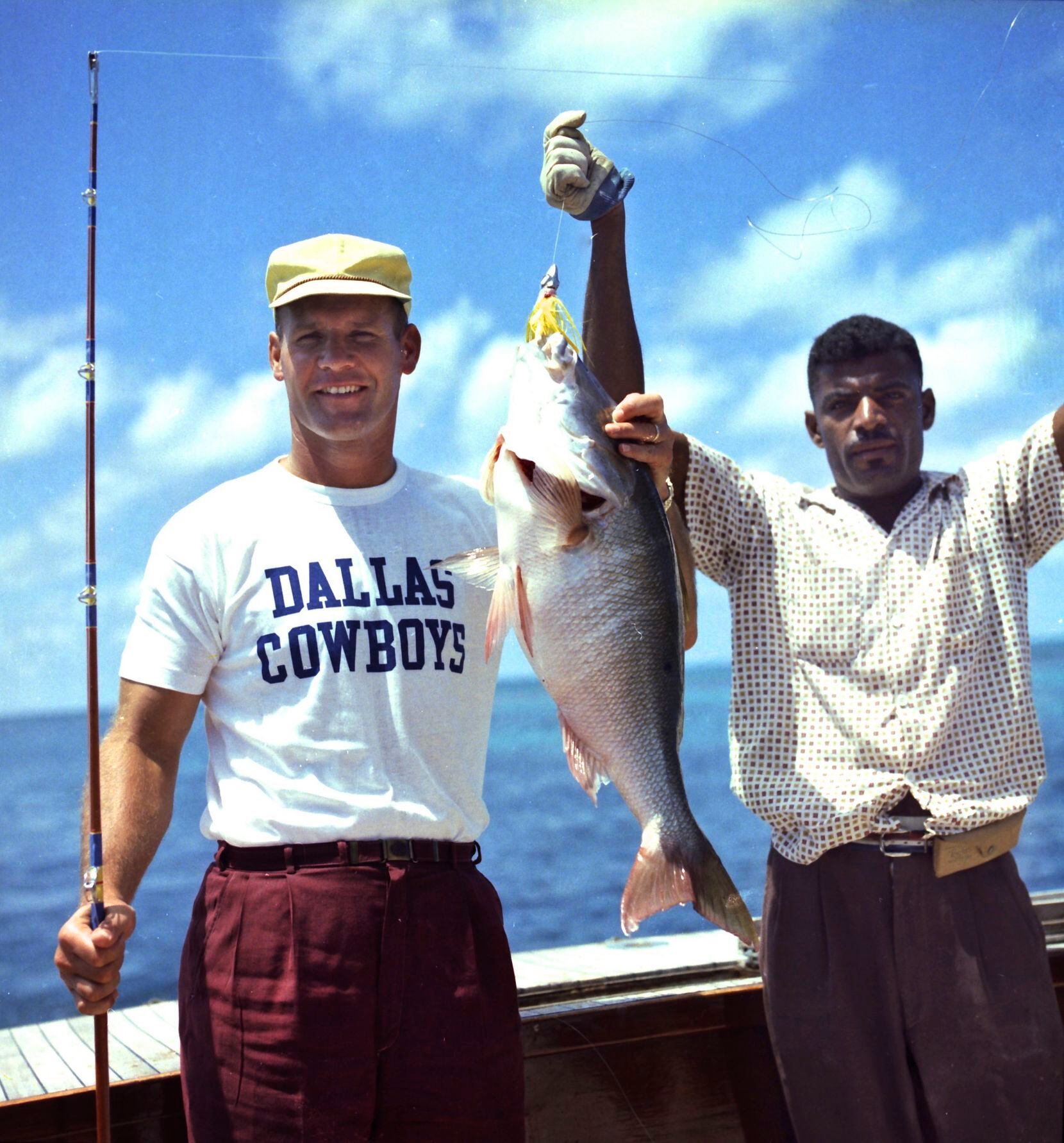 Cowboys head coach Tom Landry and an unidentified crewman shows off their catch while...