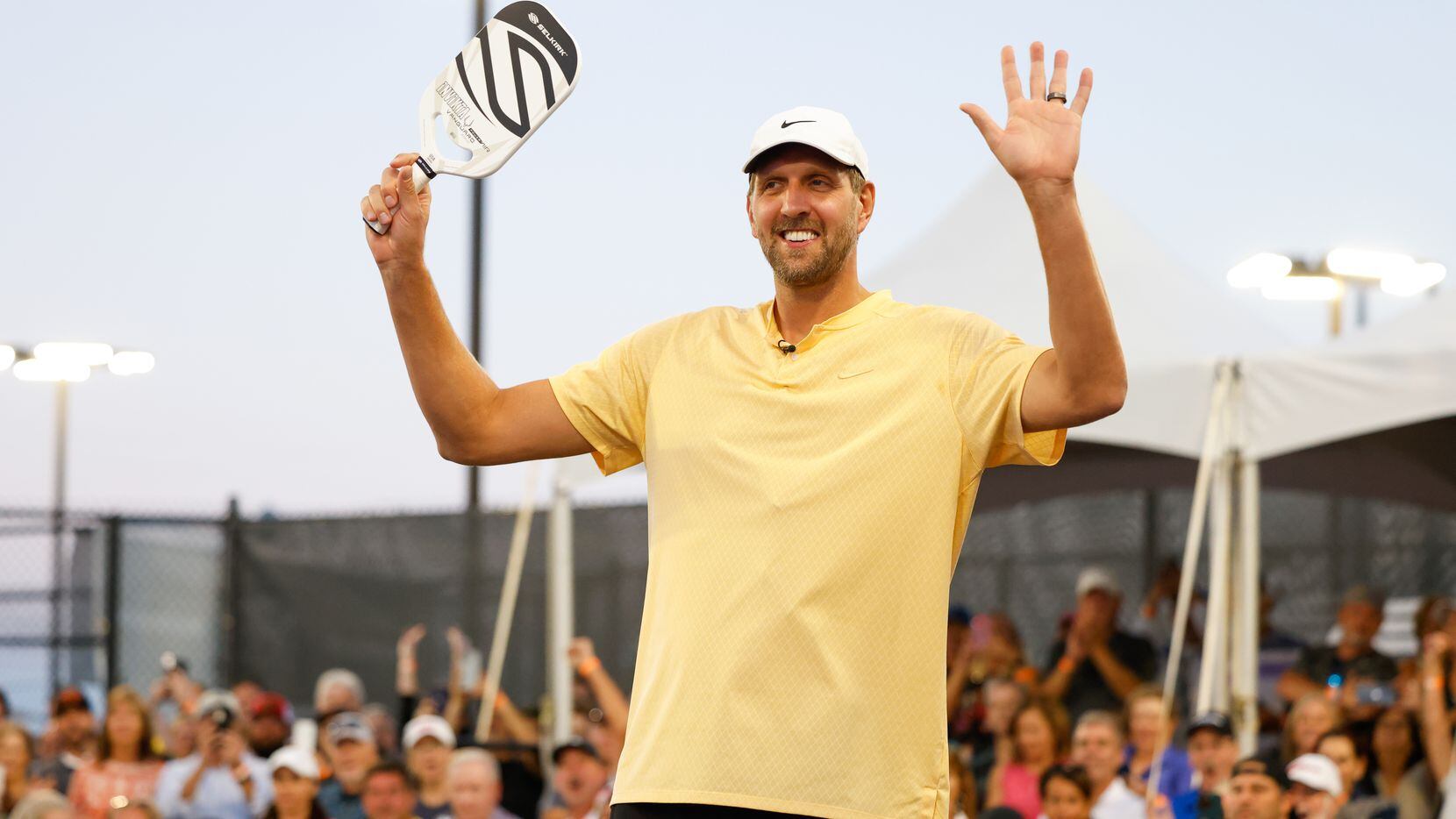 Dirk Nowitzki raises his arms as he is announced to the crowd as a pickleball player in the...