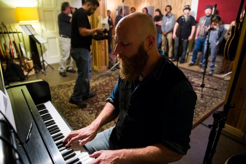 Dan Johnson plays piano as local musicians record background vocals for their version of...