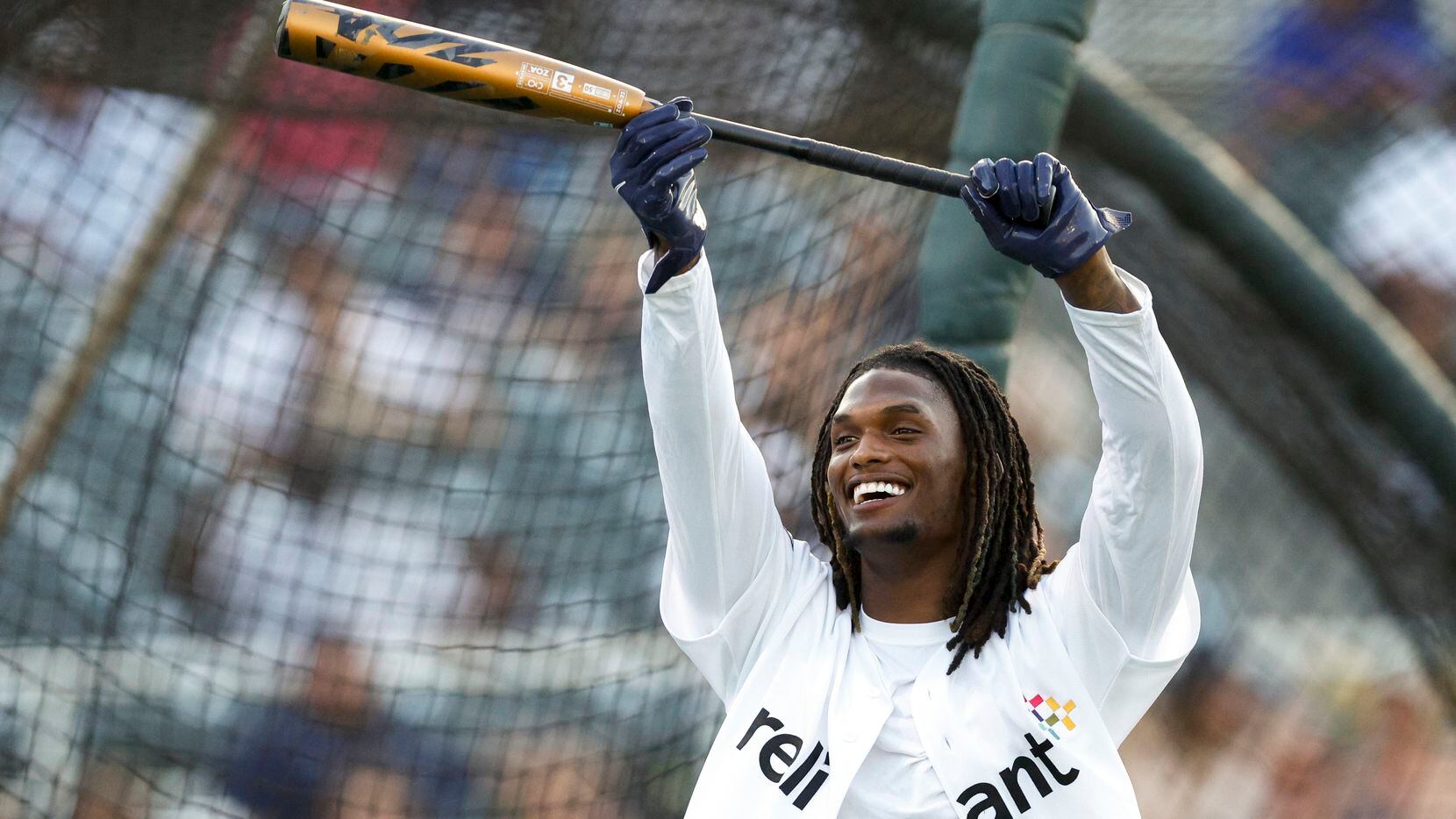 Dallas Cowboys wide receiver CeeDee Lamb raises his bat after hitting a home run during the...