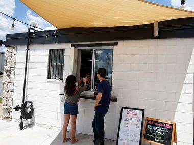 Mai La (left) and Jonathan Cheatham get their drinks from the service window at Sandwich Hag...