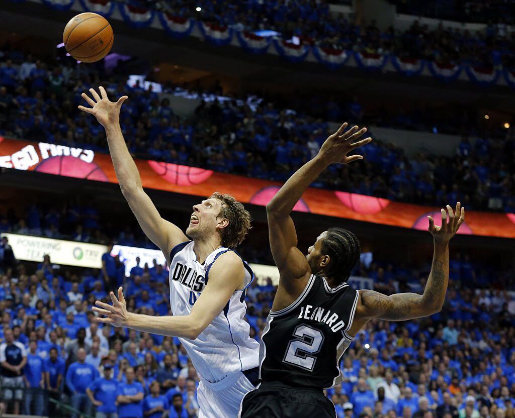 Dallas Mavericks forward Dirk Nowitzki (41) lays up a shot past San Antonio Spurs forward Kawhi Leonard (2) during the  fourth quarter of the NBA Western Conference Quarterfinals Game 4 at the American Airlines Center in Dallas, Monday, April 28, 2014. The Mavs lost 93-89. (Tom Fox/The Dallas Morning News)