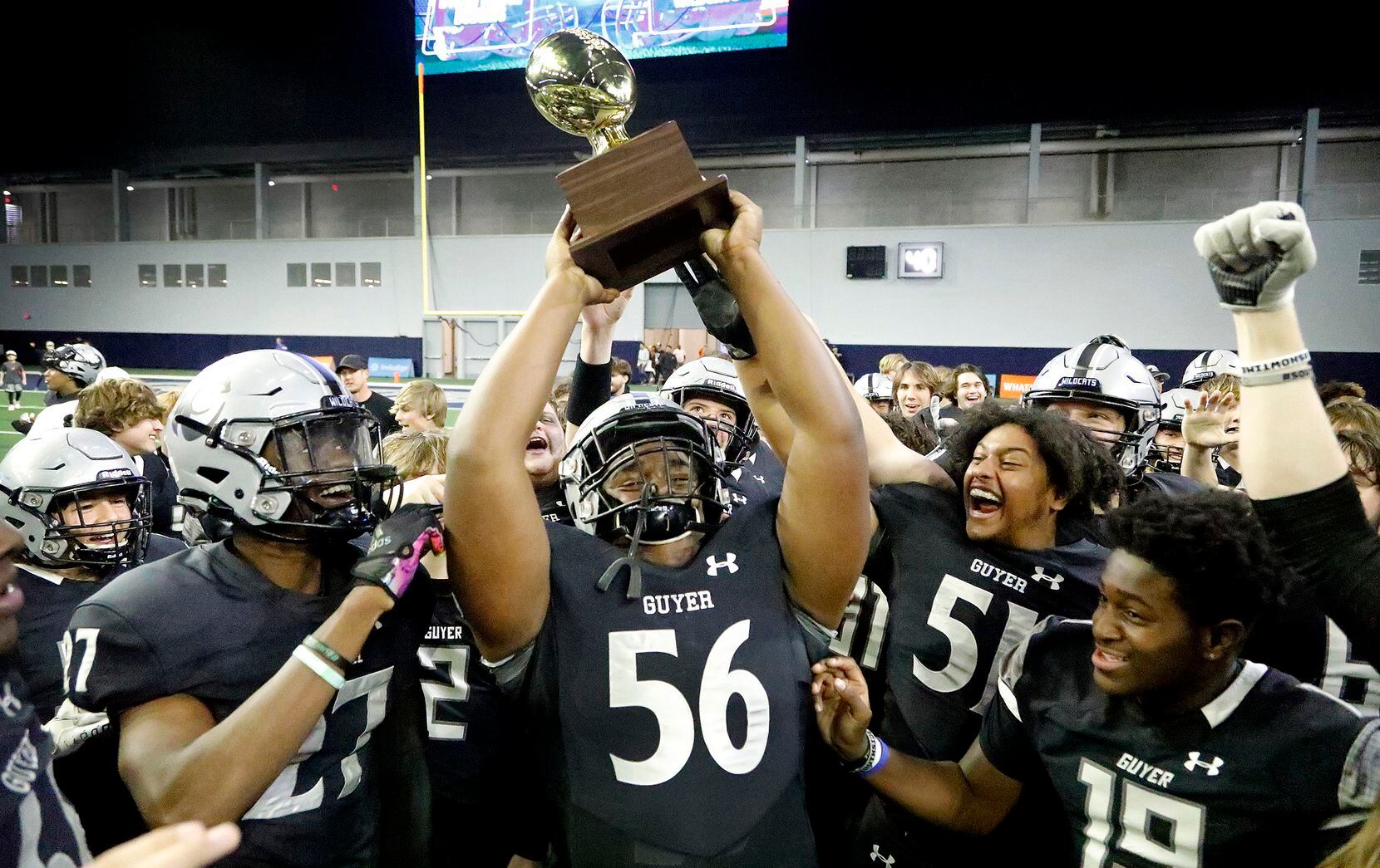 Guyer High School defensive lineman Dynell Neal (56) hoists up the trophy after the win as...