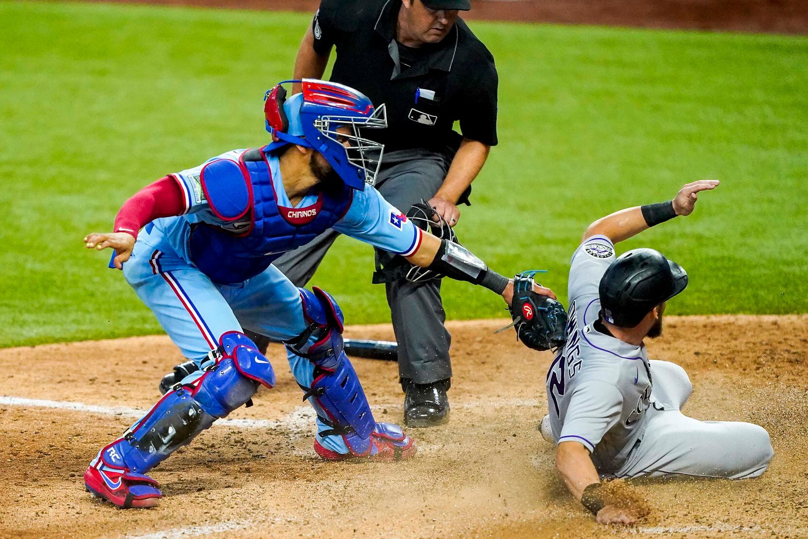 Colorado Rockies second baseman Chris Owings scores past the tag from Texas Rangers catcher...
