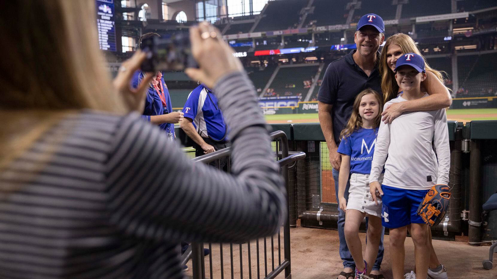Owners Eddie Burns and Tiffany Burns of Monument Realty pose with their children McKenzie and Austin before Tiffany throws the first pitch at the Rangers Game on Aug. 3 at Globe Life Field.