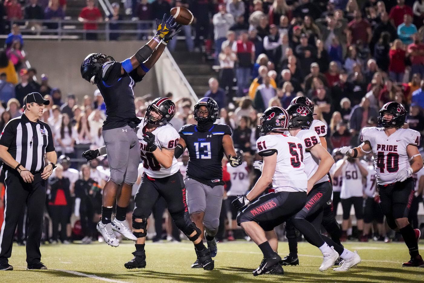Mansfield Summit defensive lineman Joseph Adedire (4) leaps to catch the ball over Colleyville Heritage offensive lineman William Baum (60) after a blocked Colleyville Heritage field goal attempt during the second half of the Class 5A Division I Region I final on Friday, Dec. 3, 2021, in North Richland Hills, Texas. (Smiley N. Pool/The Dallas Morning News)