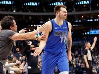 Court-side fans congratulate Dallas Mavericks guard Luka Doncic (77) after he made an inbounds steal, quickly dribbled up court and hit a last second three-pointer against the Phoenix Suns to end the first half at the American Airlines Center in Dallas, January 20, 2022.