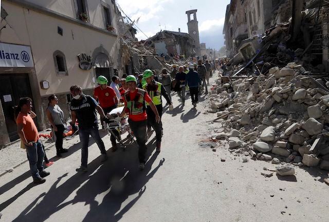 Rescatistas transportan un cadáver tras el sismo que azotó el centro de Italia....