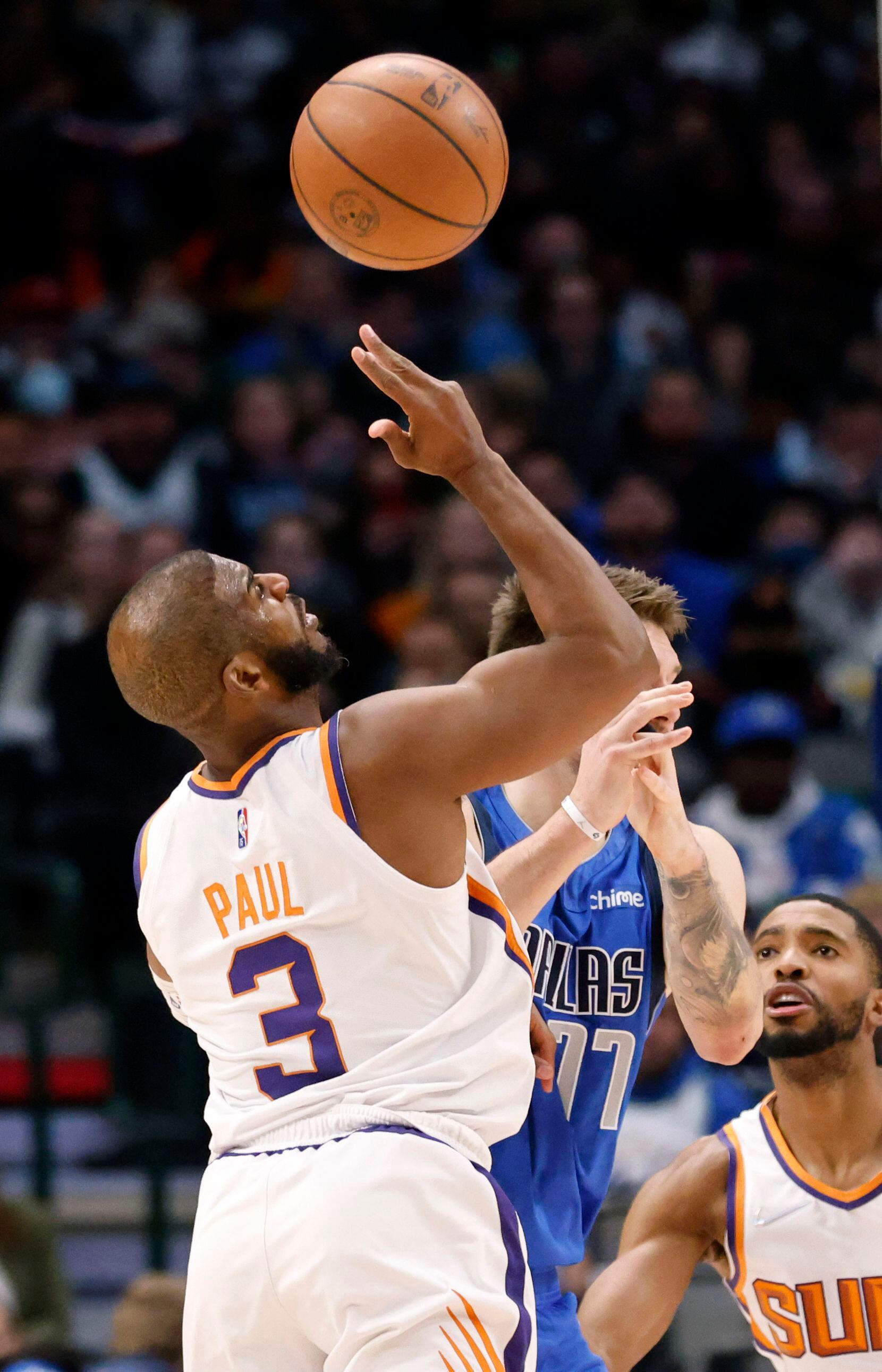 Phoenix Suns guard Chris Paul (3) pops the ball out of Dallas Mavericks guard Luka Doncic’s...