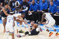 Dallas Mavericks guard Luka Doncic (77) struggles for a loose ball against Oklahoma City...