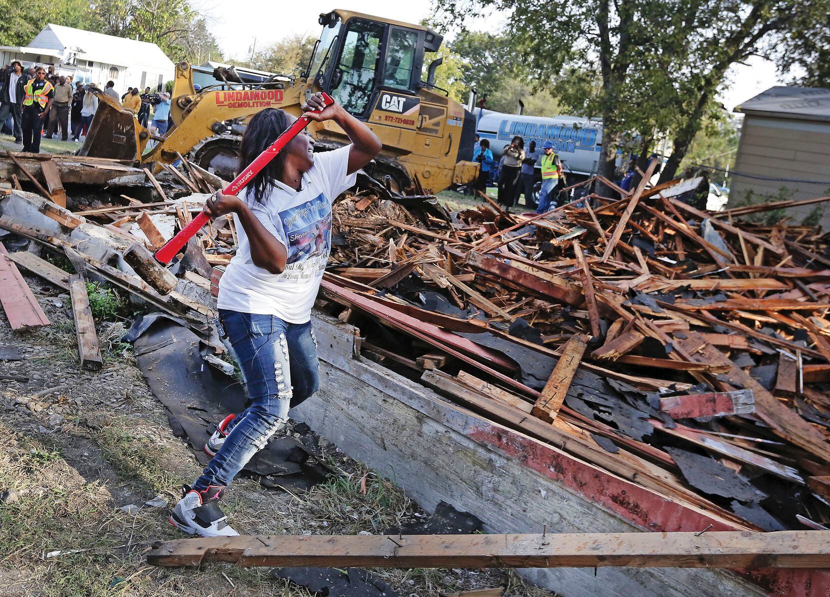 Cynthia King, Shavon Randle's great-aunt, puts the finishing whacks on "this godforsaken house" where the girl's body was found. Relatives and neighbors gathered for the demolition of the run-down structure on Kiest Boulevard in October.