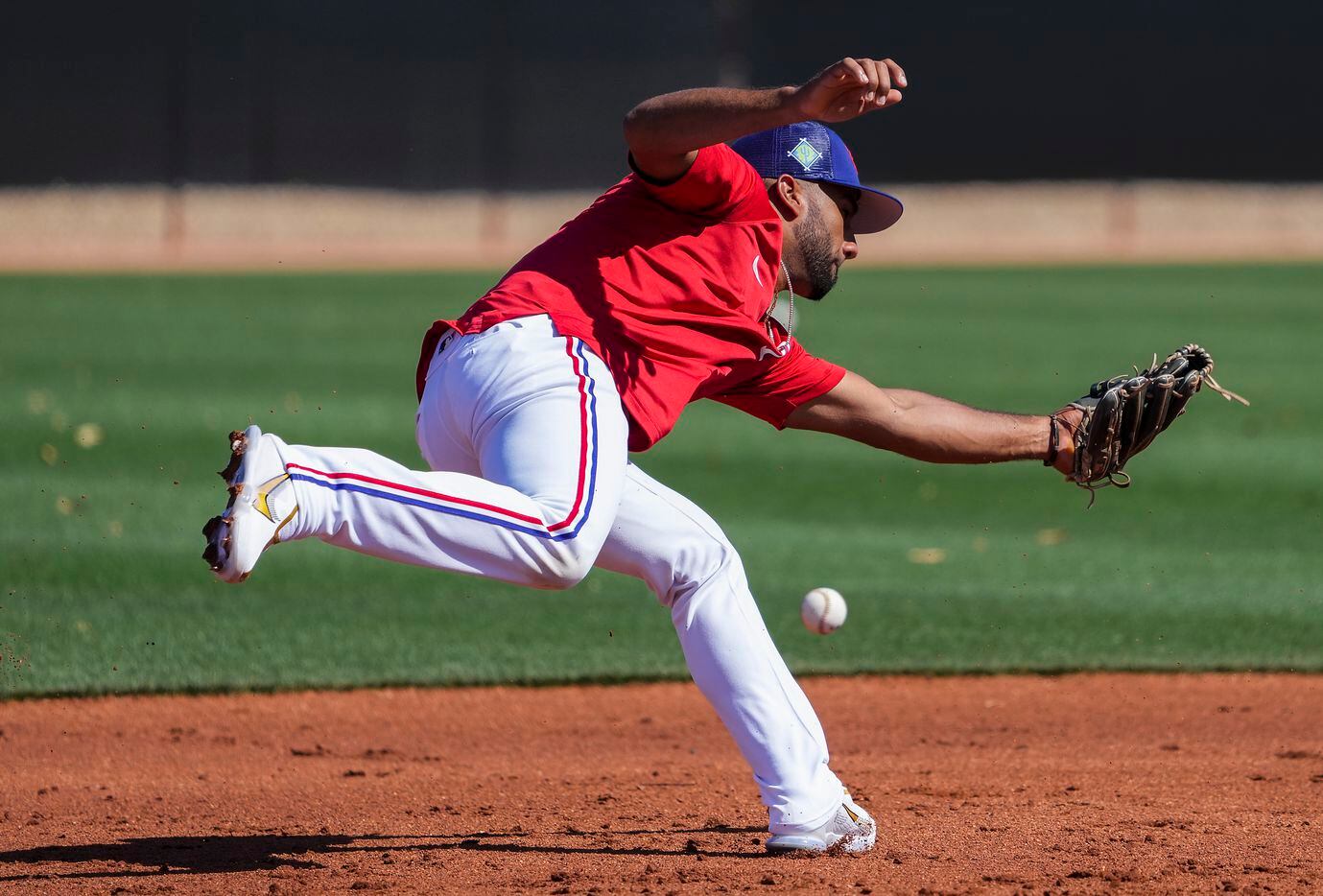 Texas Rangers infielder Ezequiel Duran reacjes for a grounder at third base during a spring...