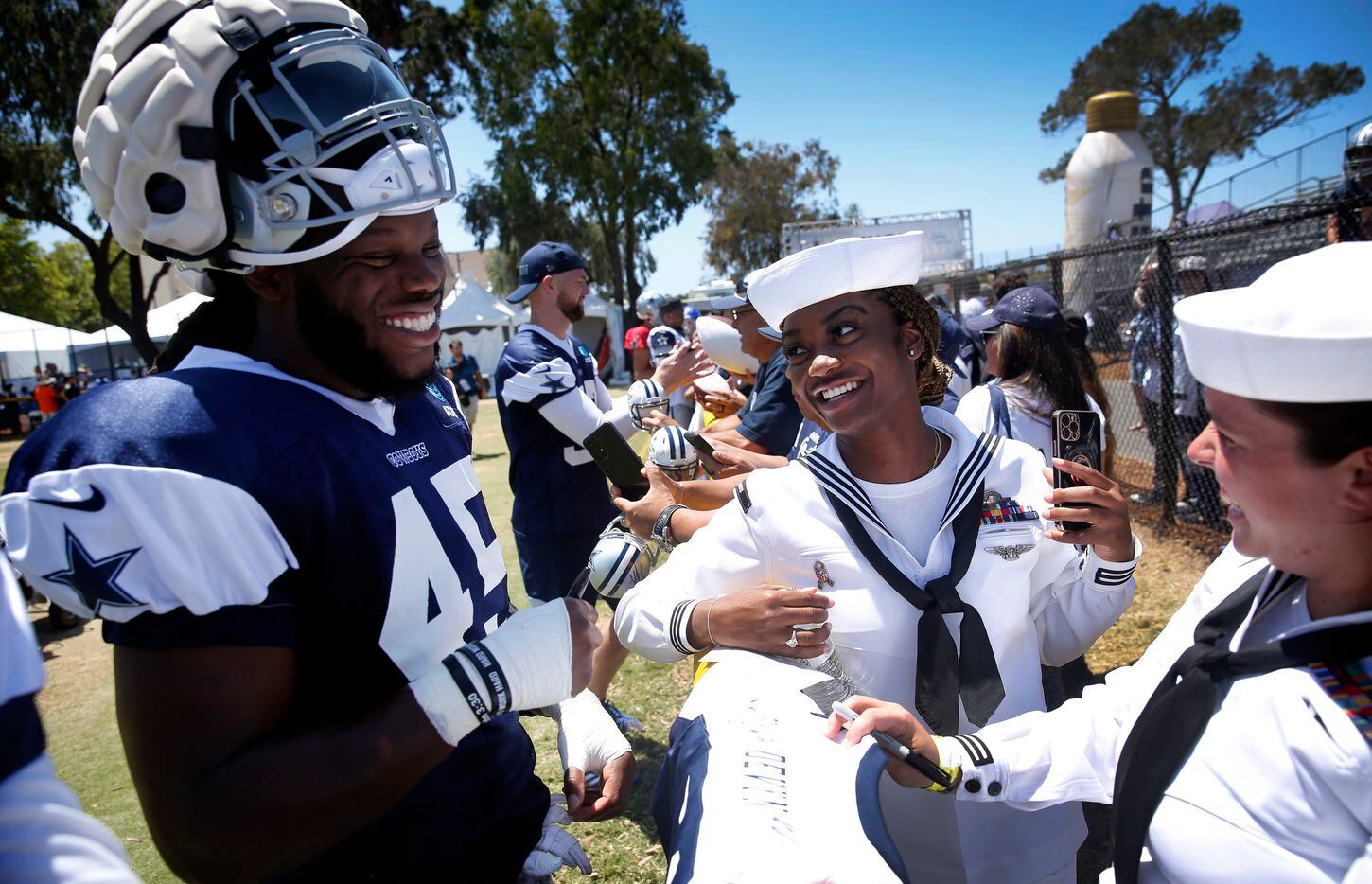 Navy logistics specialists Janisha Stout (center) laughs with Dallas Cowboys rookie...