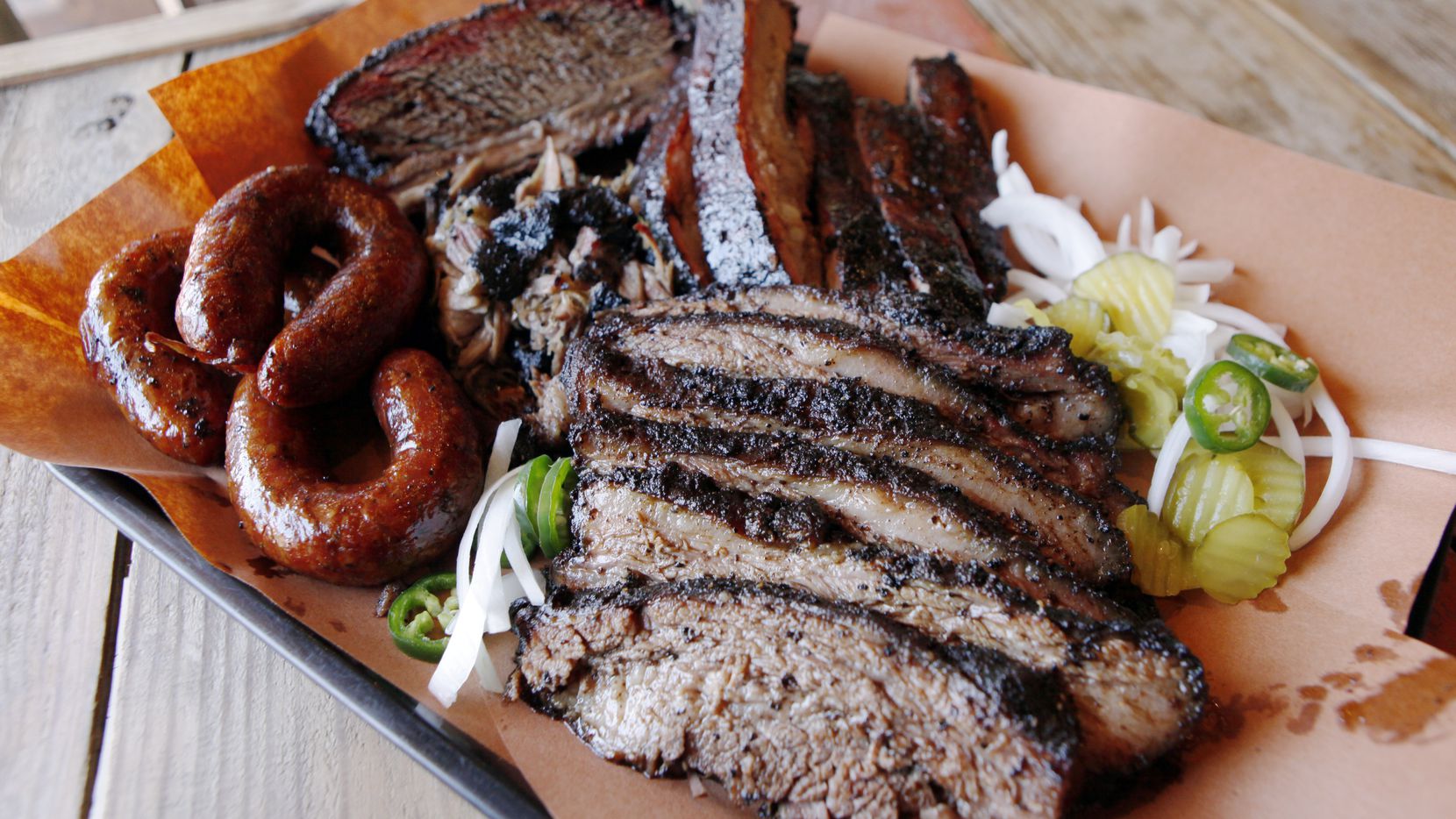 The family style platter with beef rib, brisket, pork ribs, pulled pork and sausage from the...