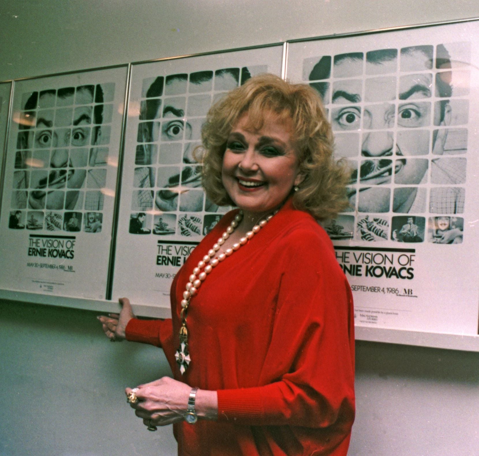 Edie Adams, the widow of Ernie Kovacs, stands next to posters of Kovacs in New York...