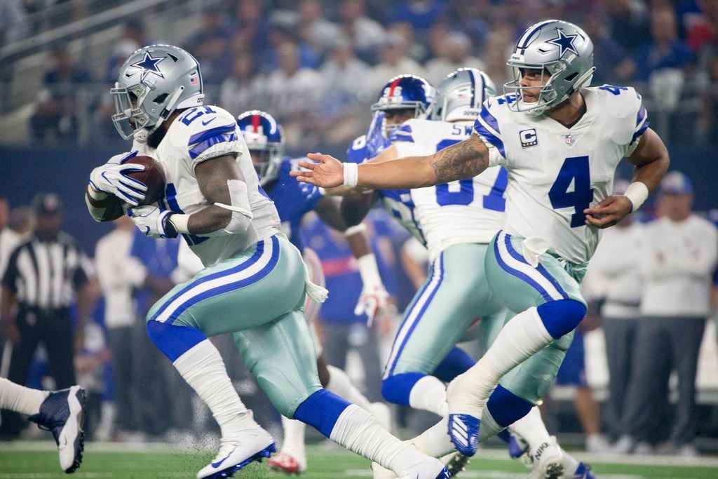Dallas Cowboys quarterback Dak Prescott (4) hands the ball off to Dallas Cowboys running...