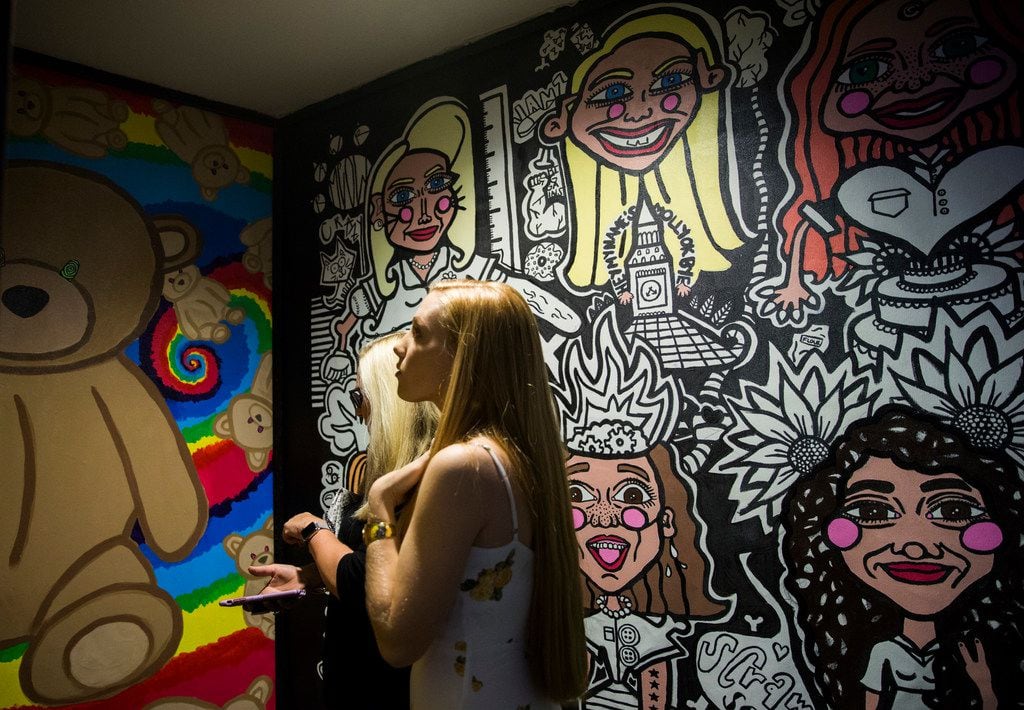 Women look at artwork inside a new pop-up art installation called Psychedelic Robot in Dallas.