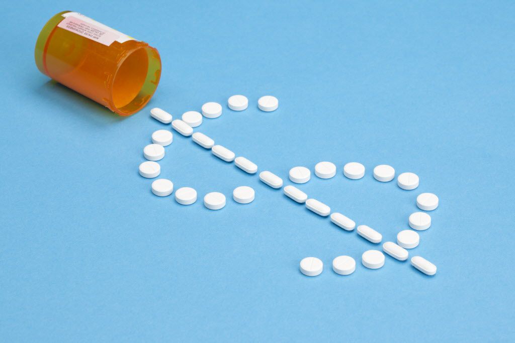 High costs of Prescription Medicine concept image. White pills in the shape of a dollar sign...