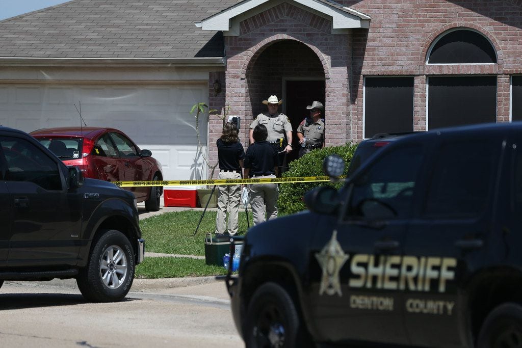 Law enforcement officers and crime scene technicians investigate at a home where five people...