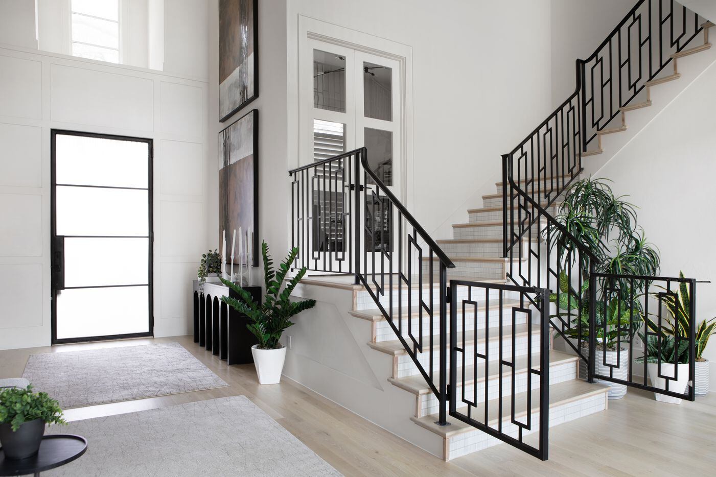 The geometric wrought-iron banister is surrounded by greenery. "The staircase was layered...