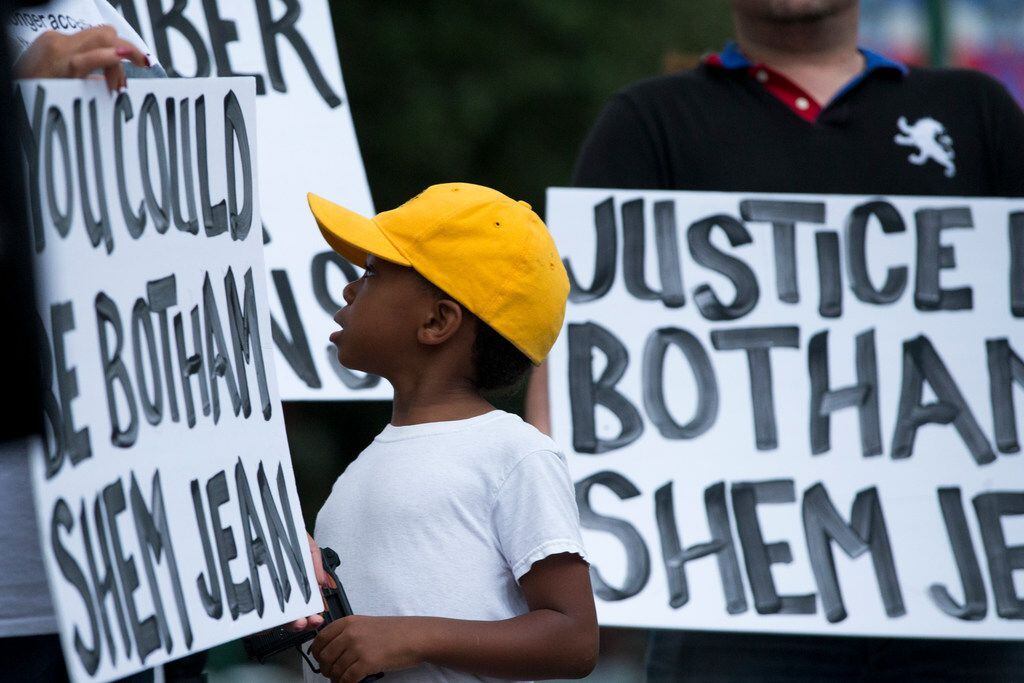 "Young King" Solomon Grayson, 6, looks over at a sign that reads "You Could be Botham Shem...
