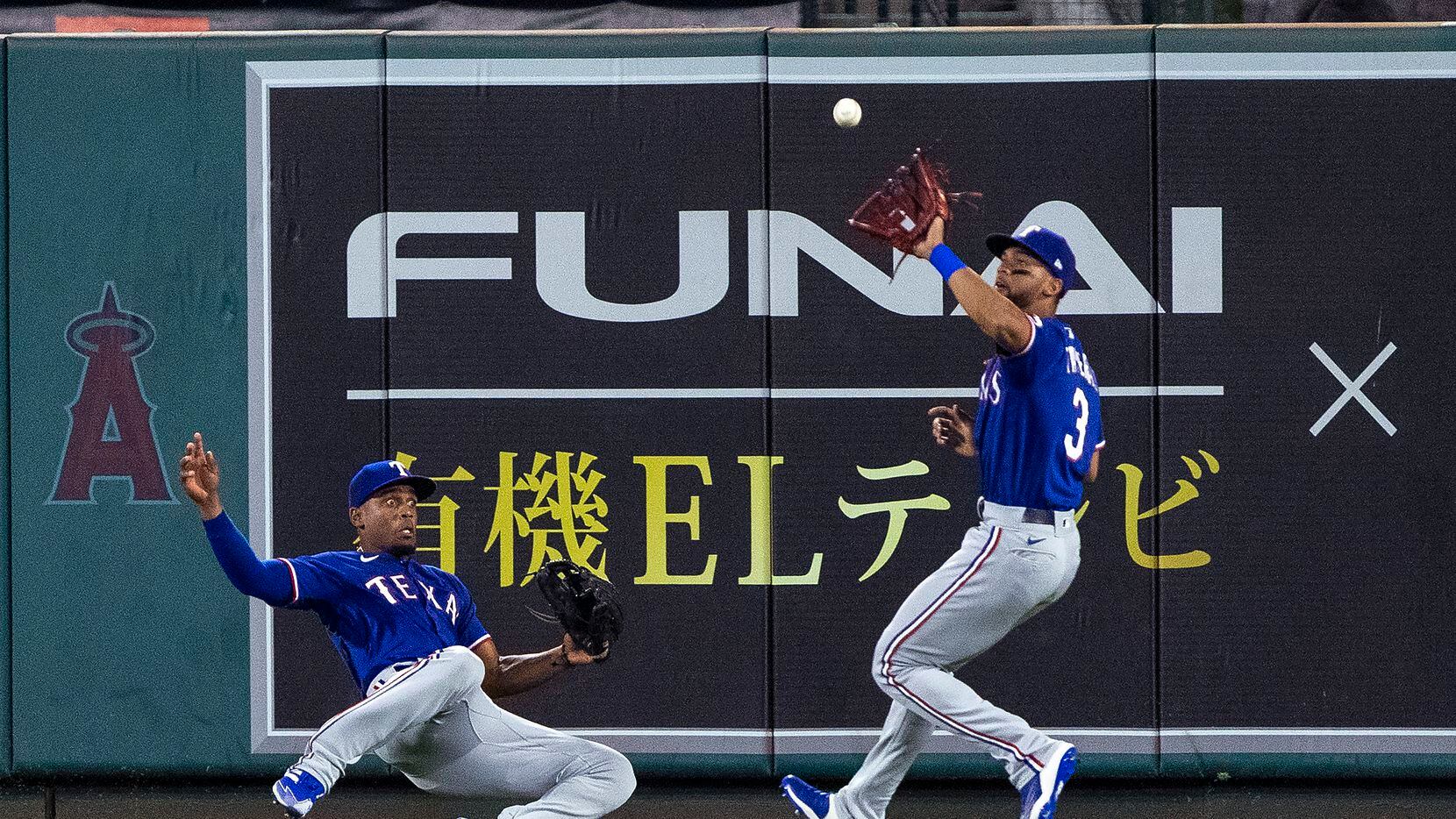 Texas Rangers center fielder Leody Taveras, right, catches a fly ball hit by Los Angeles...