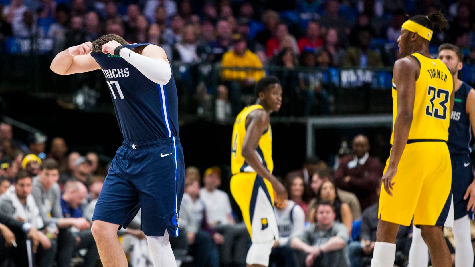 Dallas Mavericks guard Luka Doncic (77) puts his head in his shirt in response to a play...