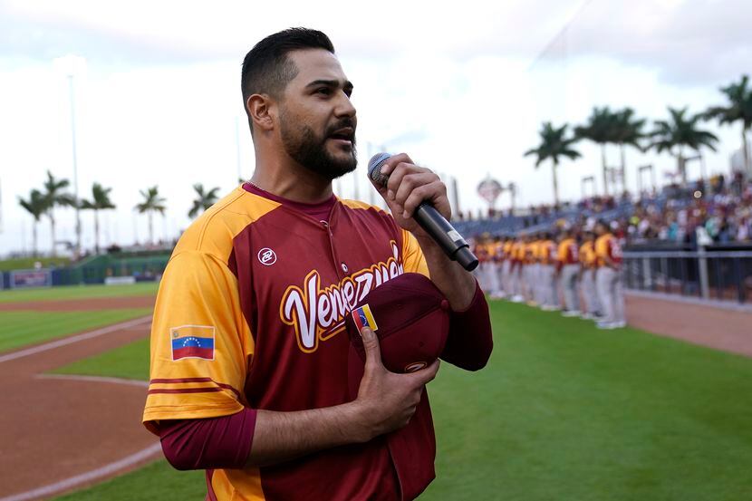 El lanzador venezolano Martín Pérez entona el himno nacional de su país previo al partido de...
