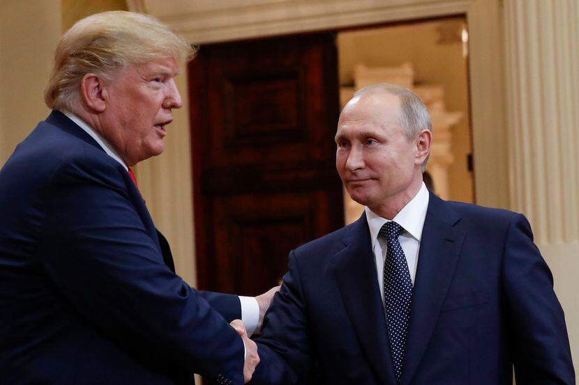 President Donald Trump, left, and Russian President Vladimir Putin shake hands at the...